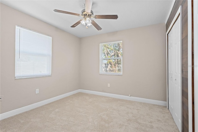 unfurnished bedroom featuring ceiling fan, a closet, and light carpet