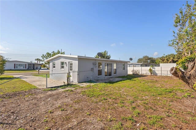 rear view of property featuring a lawn