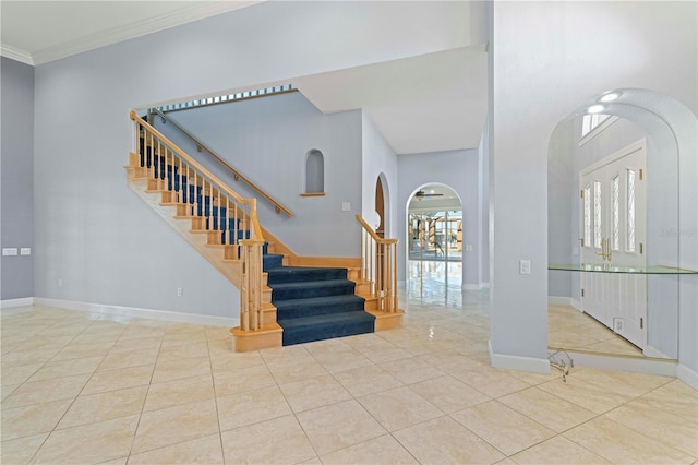 entryway featuring light tile patterned floors and ornamental molding