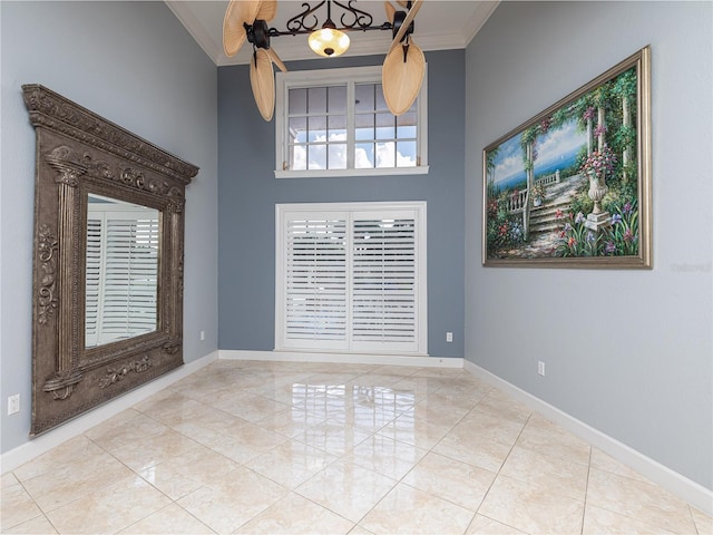 spare room with crown molding, a towering ceiling, and light tile patterned floors