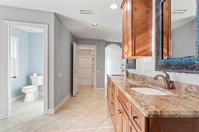 bathroom featuring vanity, tile patterned floors, and toilet