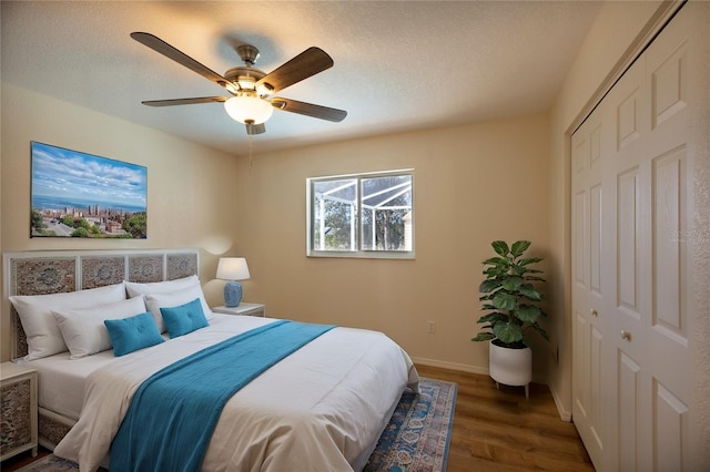 bedroom with ceiling fan, a textured ceiling, dark hardwood / wood-style flooring, and a closet