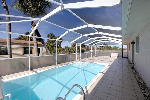 view of pool featuring an outbuilding, a lanai, and a patio