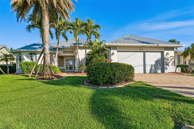 single story home with a garage, a front yard, and french doors