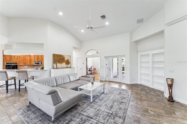 living room with ceiling fan and high vaulted ceiling