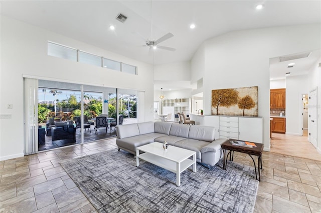 living room with ceiling fan and high vaulted ceiling