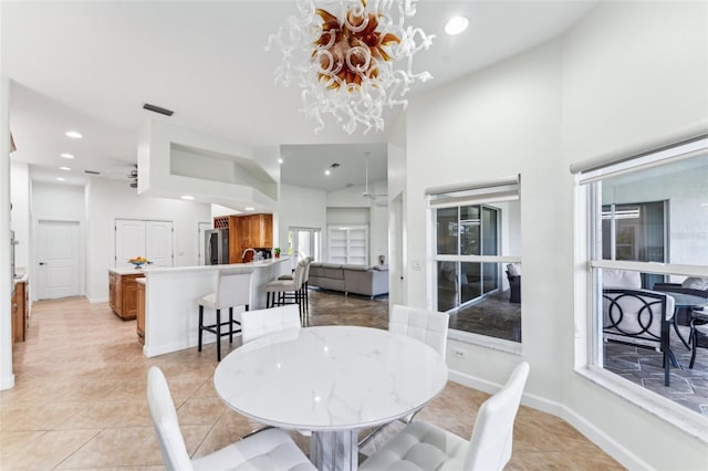 dining area featuring ceiling fan with notable chandelier and light tile patterned floors