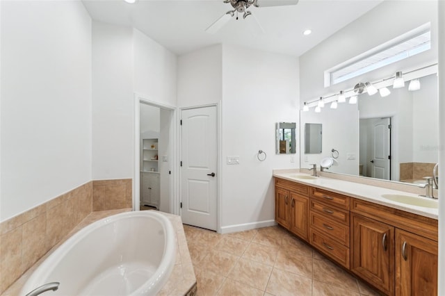 bathroom with vanity, a relaxing tiled tub, tile patterned floors, and ceiling fan