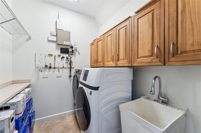 laundry area with cabinets, sink, light tile patterned floors, and washing machine and clothes dryer