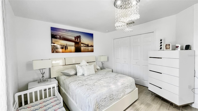 bedroom featuring an inviting chandelier and a closet