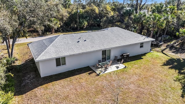 rear view of property featuring a lawn and a patio area