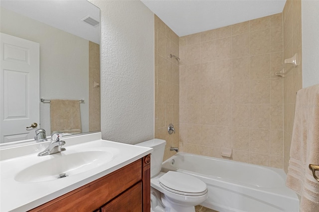 full bathroom with vanity, toilet, and tiled shower / bath combo