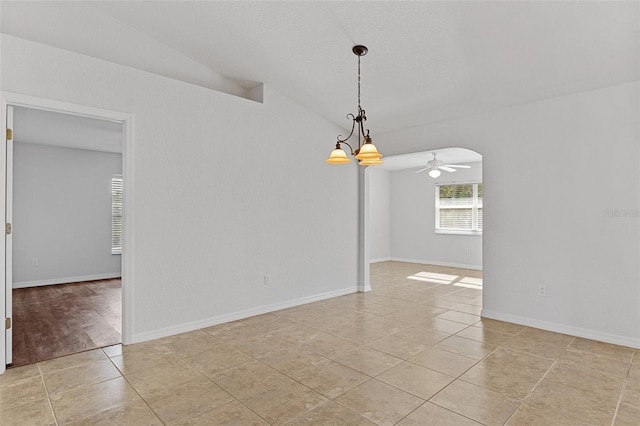 spare room featuring light tile patterned floors, ceiling fan with notable chandelier, and vaulted ceiling