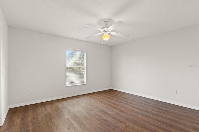 spare room with dark hardwood / wood-style flooring and ceiling fan