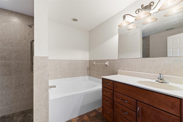 bathroom featuring vanity, separate shower and tub, and tile walls