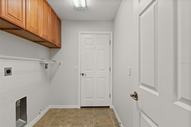 washroom with cabinets, hookup for a washing machine, a textured ceiling, and electric dryer hookup