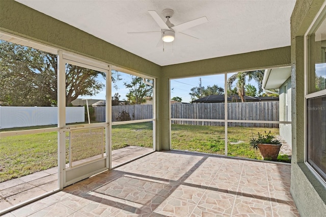 unfurnished sunroom featuring ceiling fan