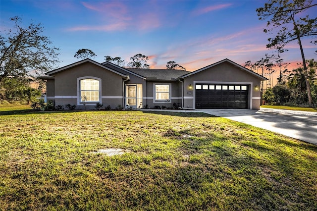 single story home featuring a garage and a lawn