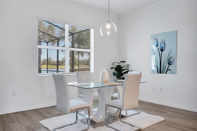 dining space featuring wood-type flooring and ornamental molding