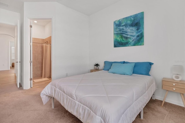 bedroom featuring ensuite bath and carpet