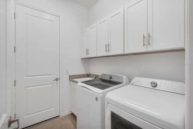 laundry area with washer and dryer, sink, and cabinets