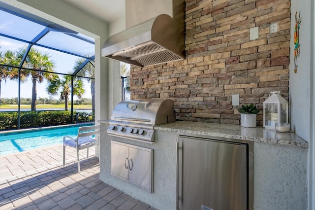 view of patio with exterior kitchen, a lanai, and a grill