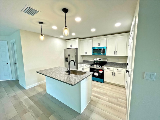 kitchen featuring white cabinetry, sink, pendant lighting, and appliances with stainless steel finishes