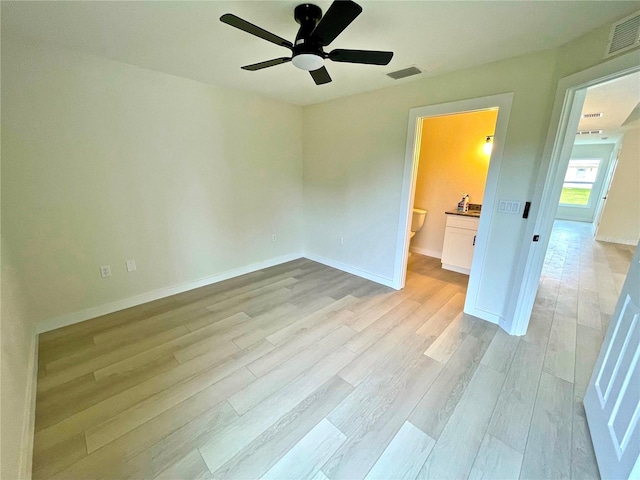 unfurnished bedroom with connected bathroom, ceiling fan, and light wood-type flooring