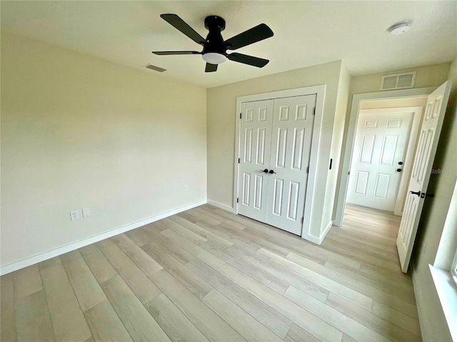 unfurnished bedroom featuring ceiling fan, light hardwood / wood-style floors, and a closet