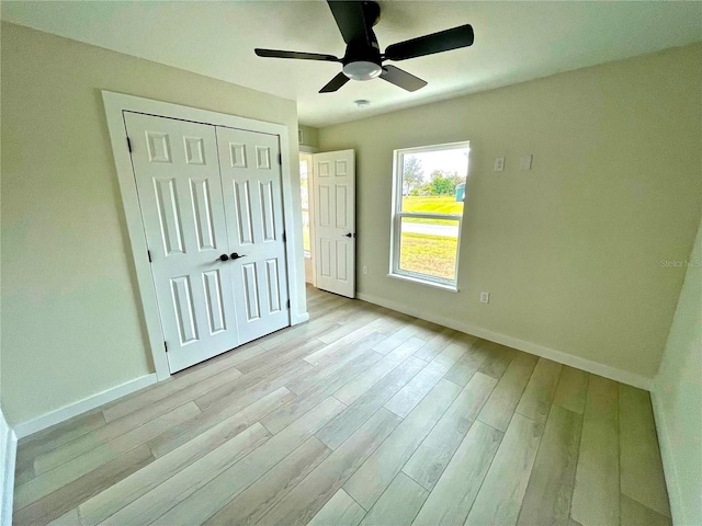 unfurnished bedroom featuring light hardwood / wood-style flooring, a closet, and ceiling fan