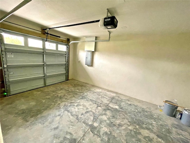 garage with a garage door opener and electric panel