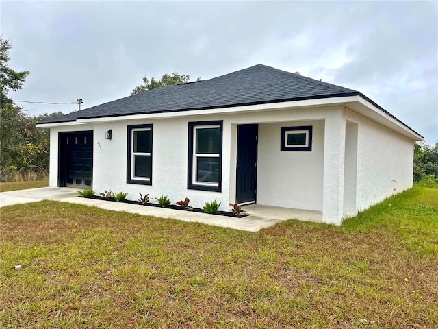 view of front of property with a garage and a front lawn