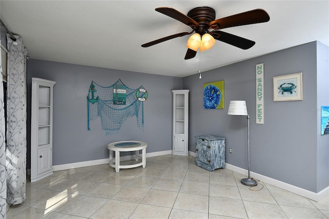 interior space with light tile patterned floors and ceiling fan