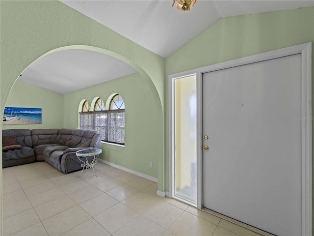 foyer entrance featuring light tile patterned flooring and vaulted ceiling