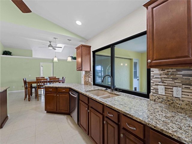 kitchen featuring sink, light tile patterned floors, dishwasher, lofted ceiling with skylight, and decorative light fixtures