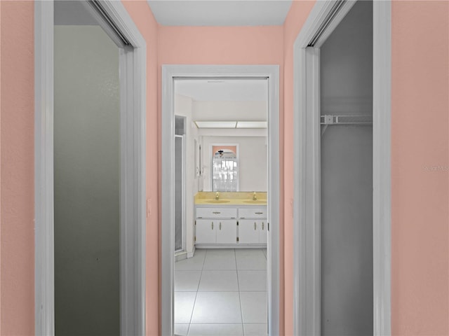 hallway featuring sink and light tile patterned floors