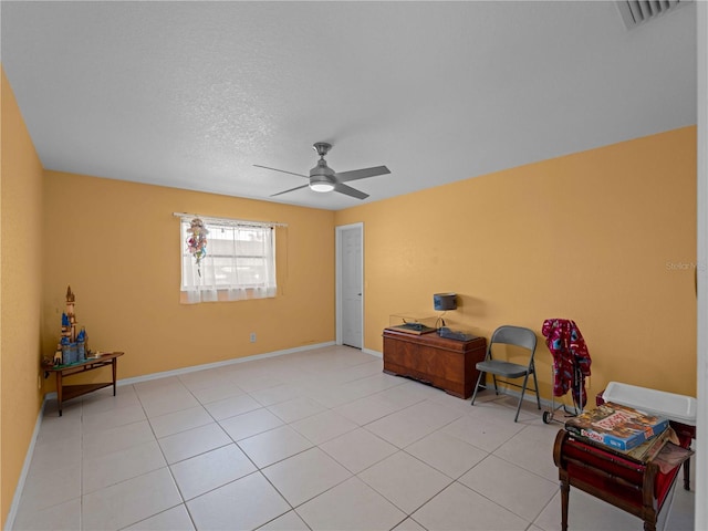 sitting room with light tile patterned floors, a textured ceiling, and ceiling fan