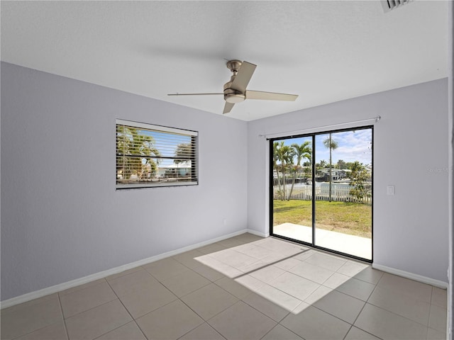 tiled empty room featuring ceiling fan