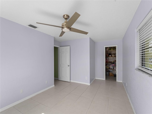 empty room featuring ceiling fan and light tile patterned flooring