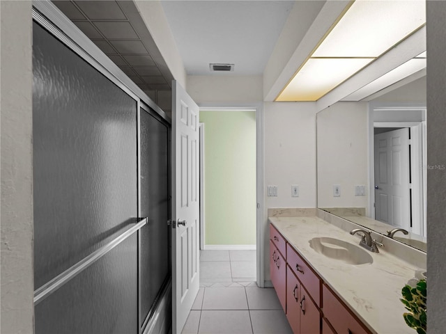 bathroom featuring tile patterned flooring, vanity, and a shower with shower door