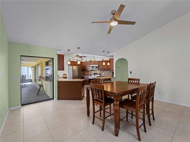 dining area with light tile patterned flooring, ceiling fan, and vaulted ceiling