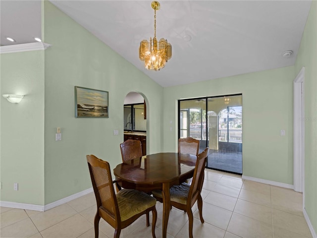 tiled dining room with a notable chandelier, vaulted ceiling, and sink