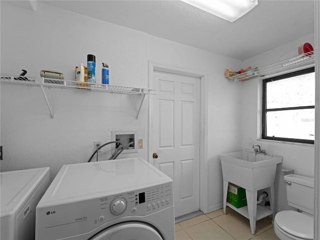 laundry room with light tile patterned floors and washing machine and clothes dryer