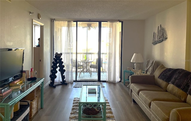 living room with floor to ceiling windows, dark wood-type flooring, and a textured ceiling