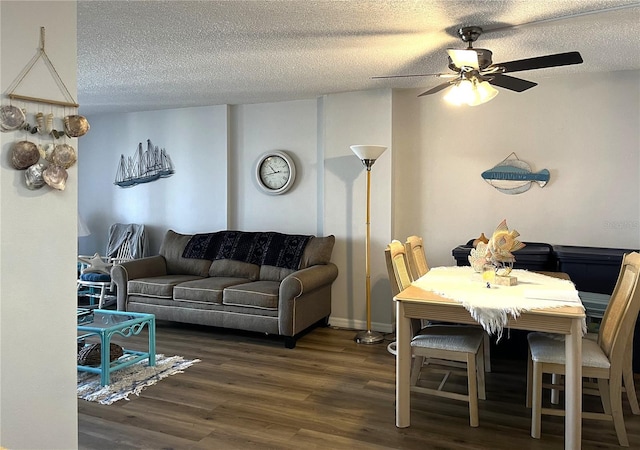 living room with ceiling fan, dark hardwood / wood-style floors, and a textured ceiling