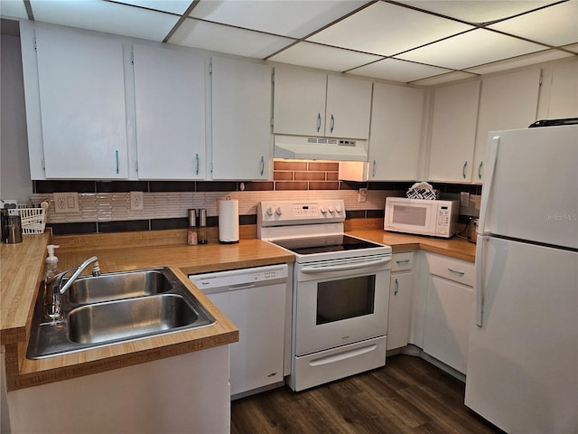 kitchen featuring sink, white appliances, dark wood-type flooring, white cabinetry, and backsplash