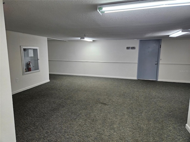 interior space featuring dark colored carpet and a textured ceiling