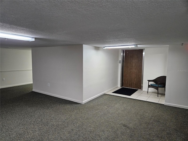 finished basement featuring a textured ceiling, baseboards, and light colored carpet