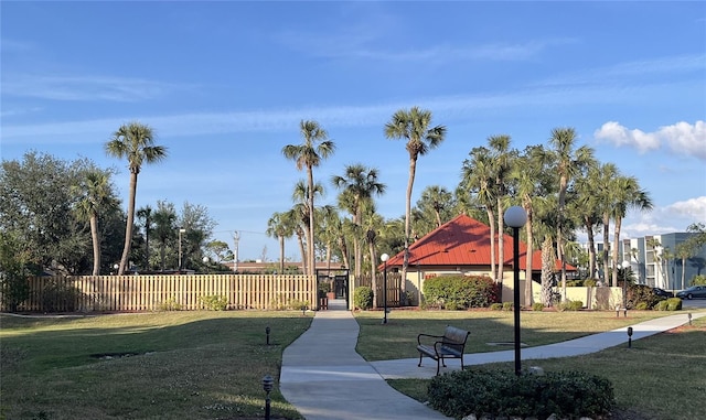 view of property's community with a yard and fence