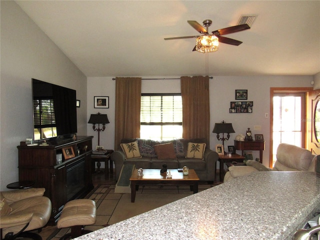 living room with lofted ceiling, tile patterned floors, and ceiling fan